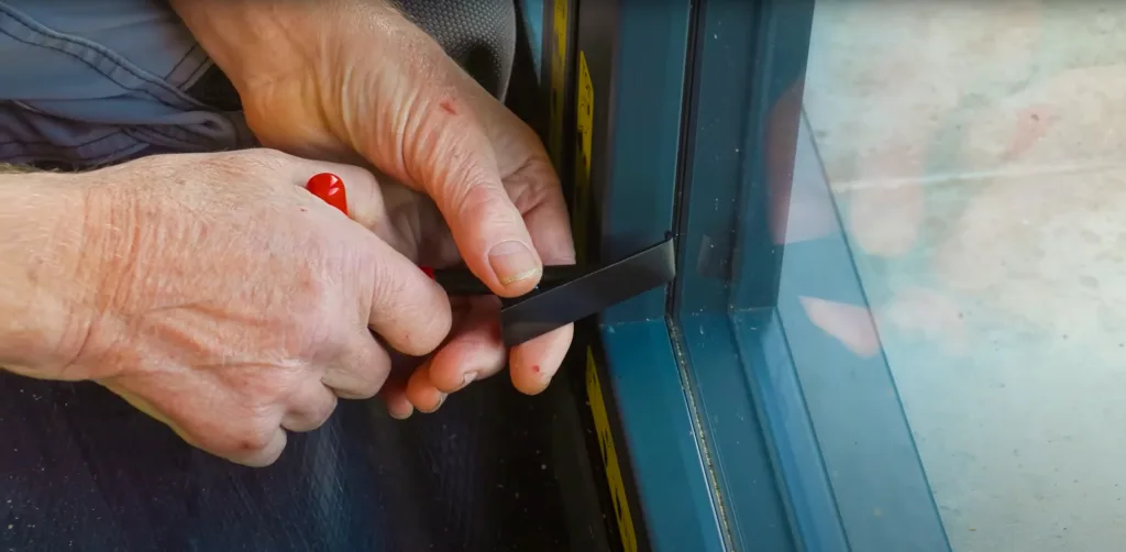 A close-up of a worker using the speedbead glazing system on a Korniche Bi-folding door.