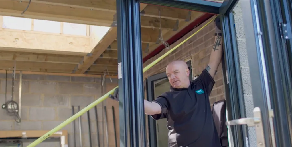 Measuring a door frame with a tape measure, ensuring it's plumb and level.