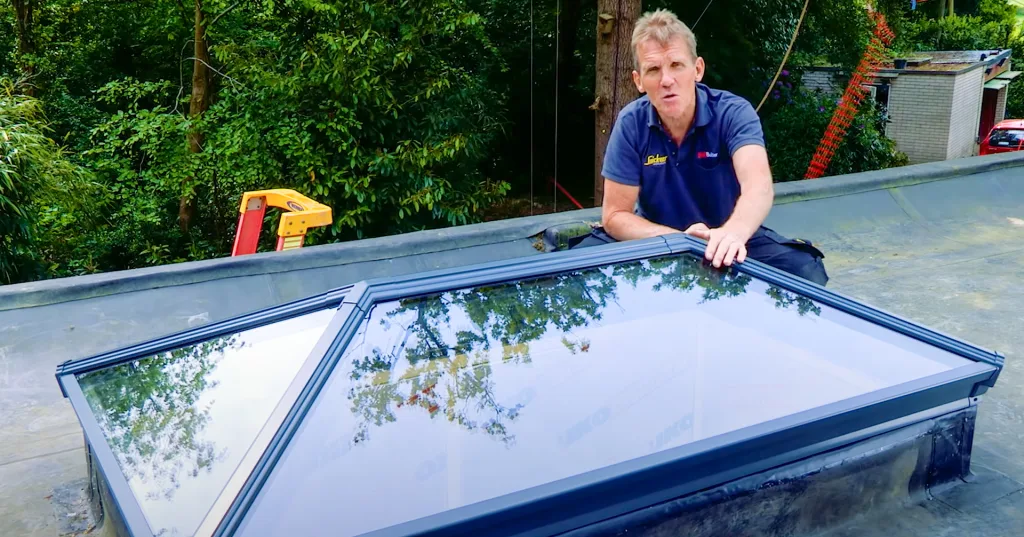 Roger Bisby sitting on a roof, admiring his brand new Korniche Roof Lantern.