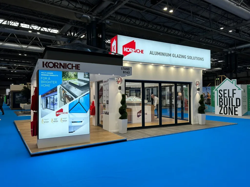 A close-up of the Korniche Aluminium Glazing Solutions booth at a homebuilding and renovating show, highlighting their multi-award winning products.