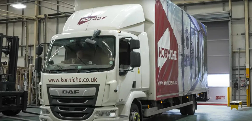 Photo of a Made for Trade Korniche delivery van parked in a loading bay. Team members are carefully loading new Korniche bi-fold doors into the back of the van.