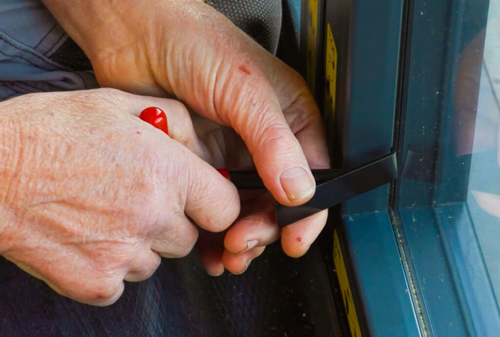 This image showcases the ease of installing the Korniche Speedbead System. Here, Roger Bisby demonstrates the simple process of pushing the pre-gasketed clip-in bead into place using just his thumb and hand.