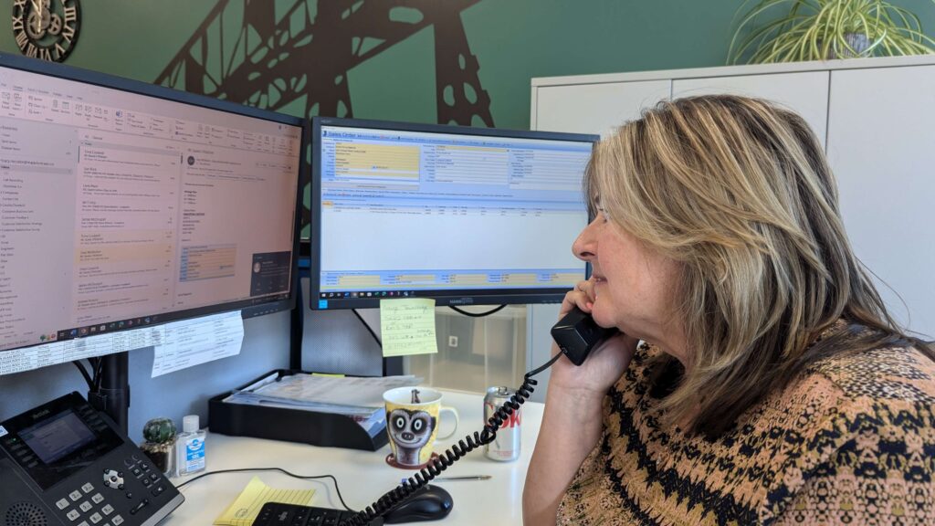 Tracy, Head of Customer Services, speaking on the phone at her desk.